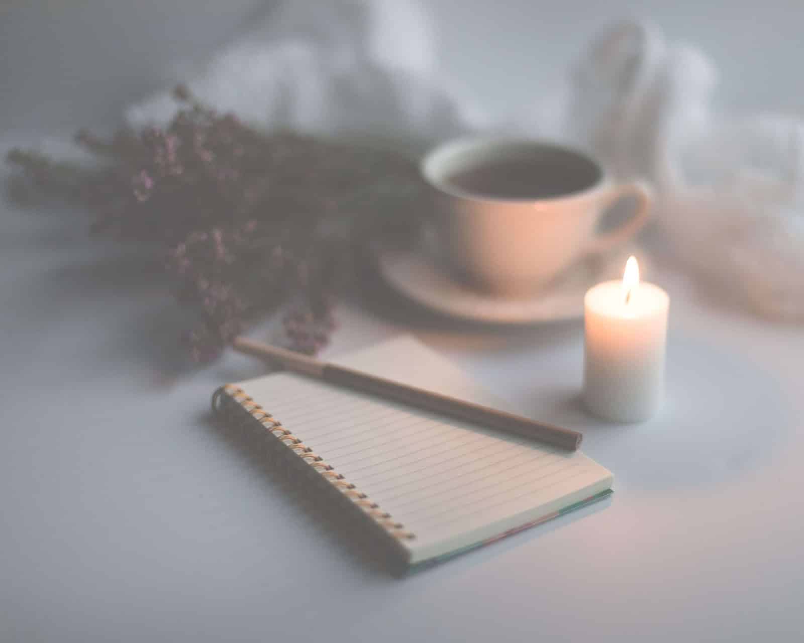journal with tea, candles, and flowers