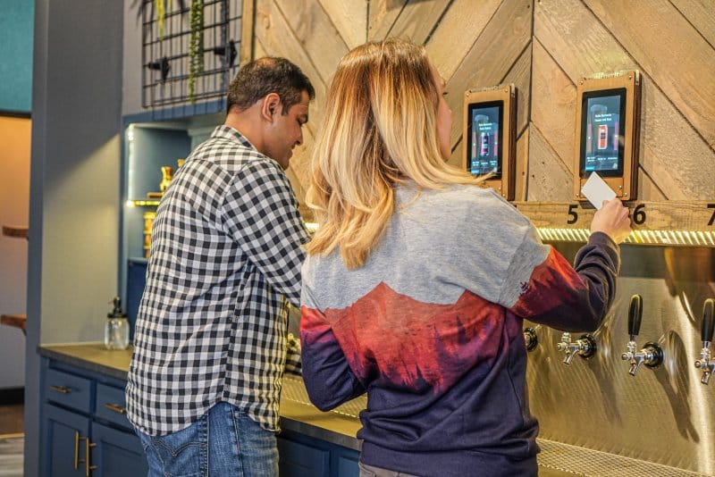 couple at self-serve beer wall at Oakwell Beer Spa in Denver