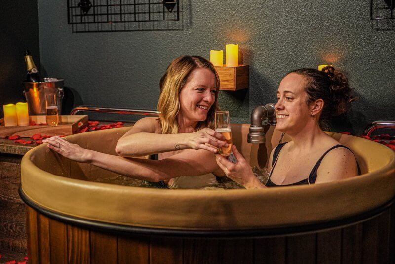 two women taking a beer bath couples spa package in Denver at Oakwell Beer Spa 