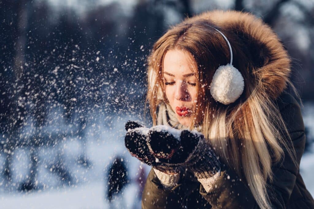woman outside in the snow with ear muffs