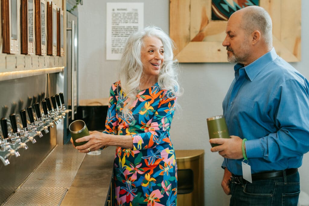 A couple smiles at each other as they select a drink from Oakwell’s self-pour beer wall