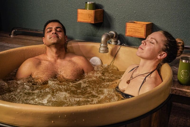 man and woman lying back and relaxing in a beer bath at Oakwell Beer Spa in Denver