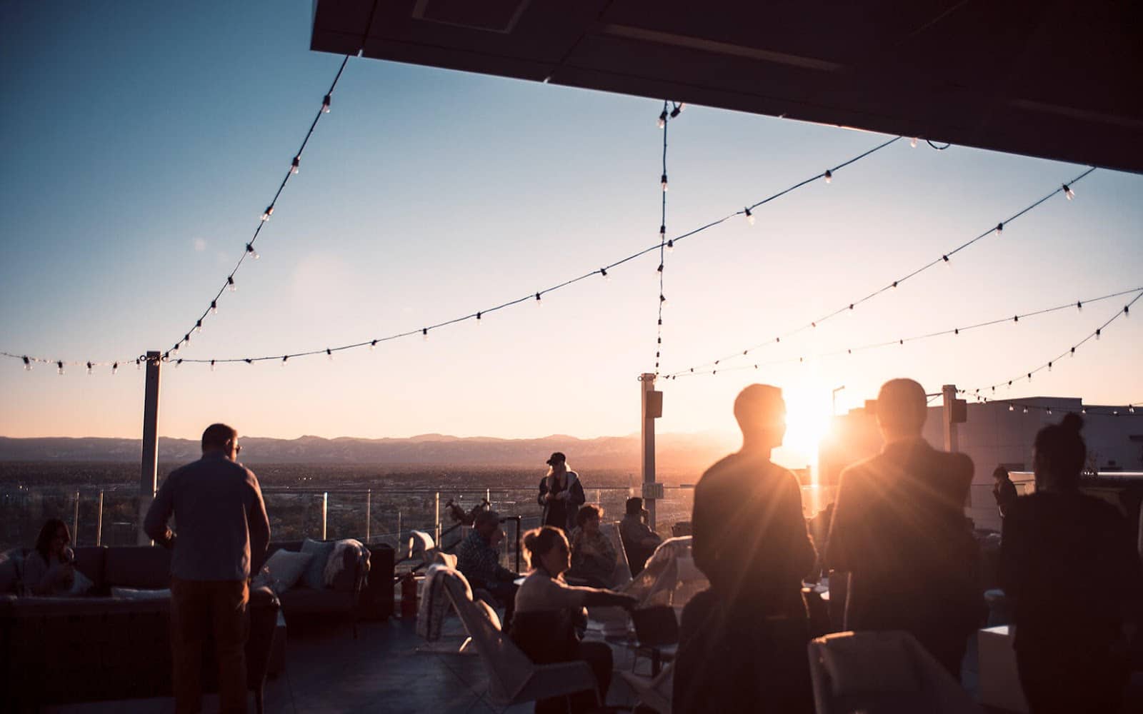 People at 54Thirty Rooftop sitting and standing surrounded by mountain scenery