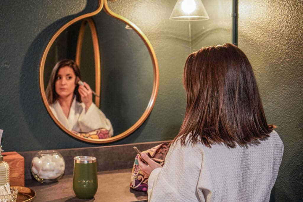 A woman applies makeup after enjoying a Mother’s Day in Denver at Oakwell