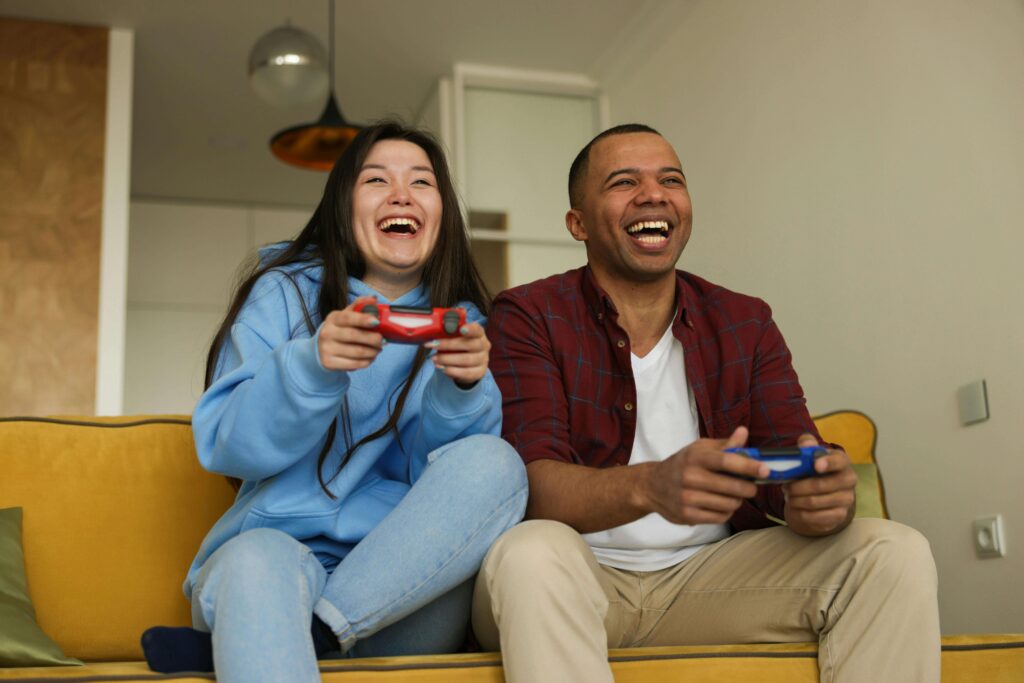 Couple smiling and playing video games together for at-home date night
