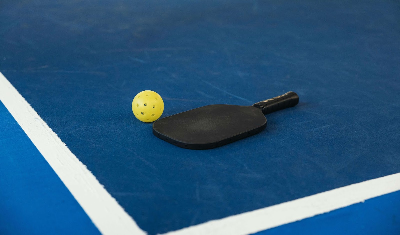 pickleball paddle and ball on court