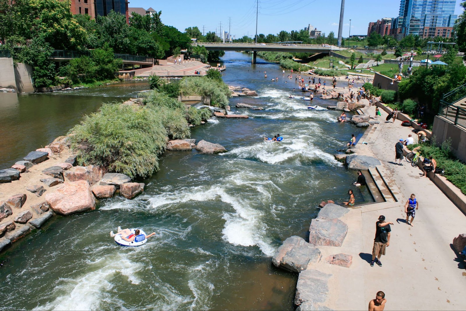 People walking around and floating in Cherry Creek in Denver