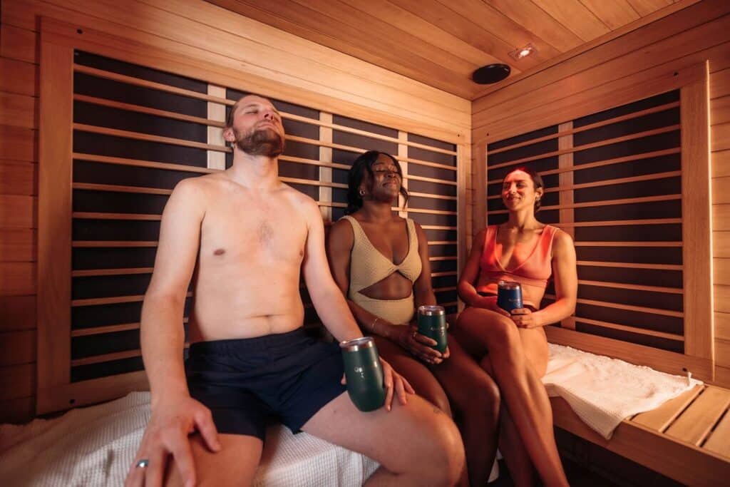 Three people relaxing in infrared sauna at Oakwell Beer Spa in Denver