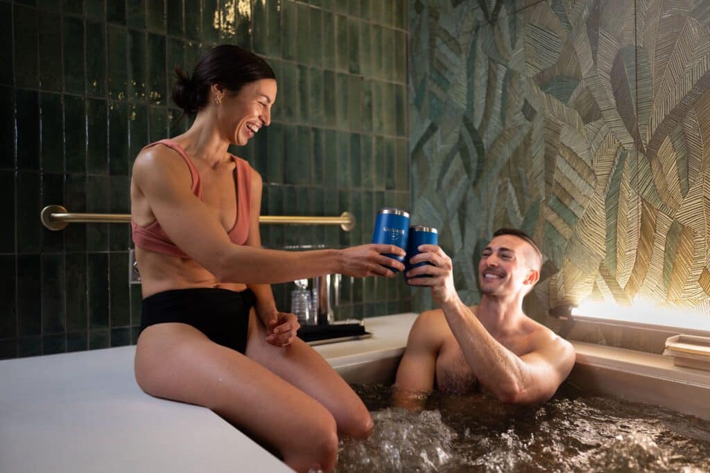 A couple toasts as they enjoy their private herbal beer-infused bath