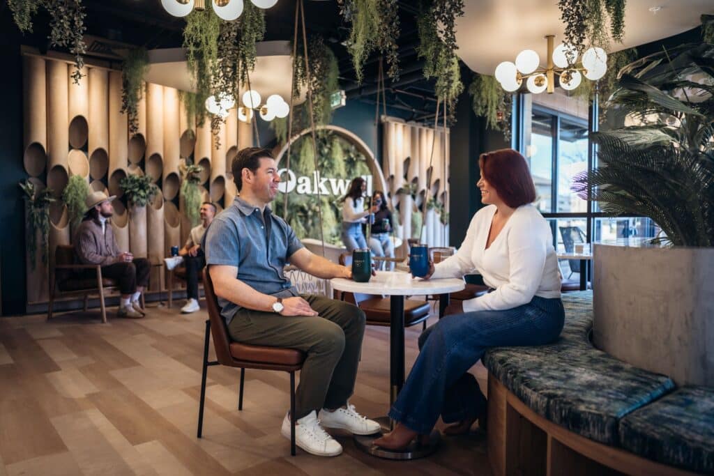 A couple chats and enjoys craft beverages in the Oakwell taproom