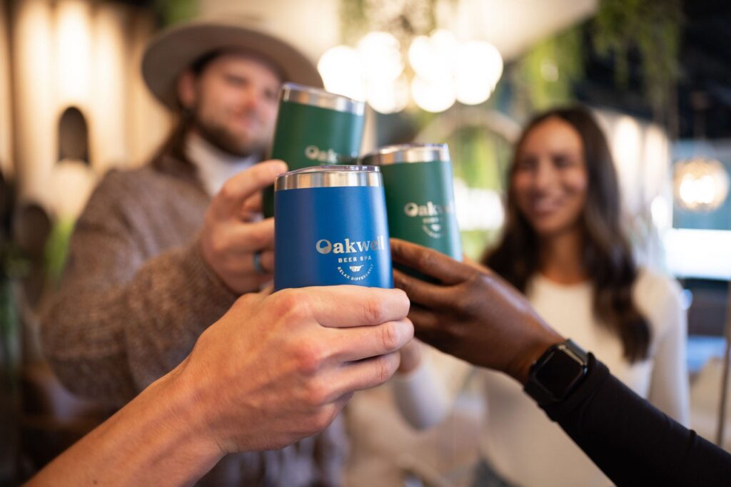 Two couples toast their glasses in the Oakwell taproom