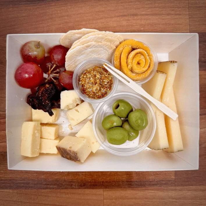 Oakwell’s vegetarian charcuterie board includes multiple cheeses, mustard, crackers, olives, and fruit